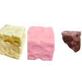 Three colorful cube-shaped cheese squishy stress relief fidget toys in white pink and brown with textured hole surfaces