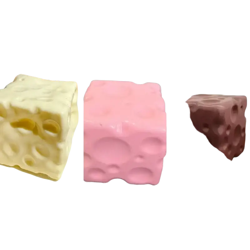 Three colorful cube-shaped cheese squishy stress relief fidget toys in white pink and brown with textured hole surfaces