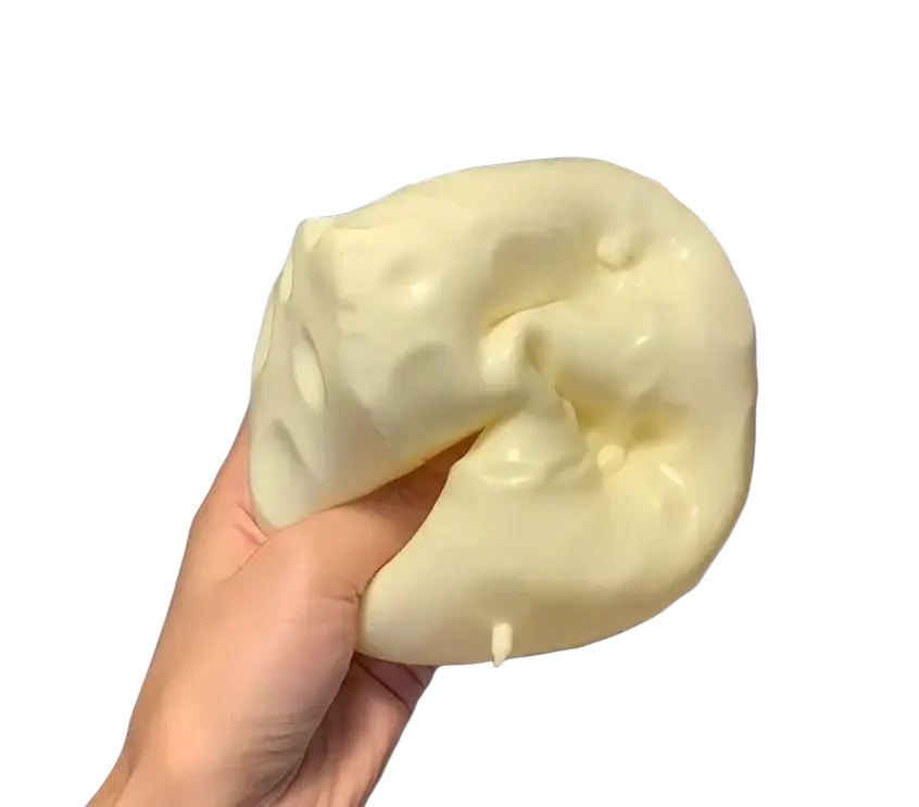 A pale yellow cheese squishy toy with a glossy surface and small hole indentations for sensory stress relief