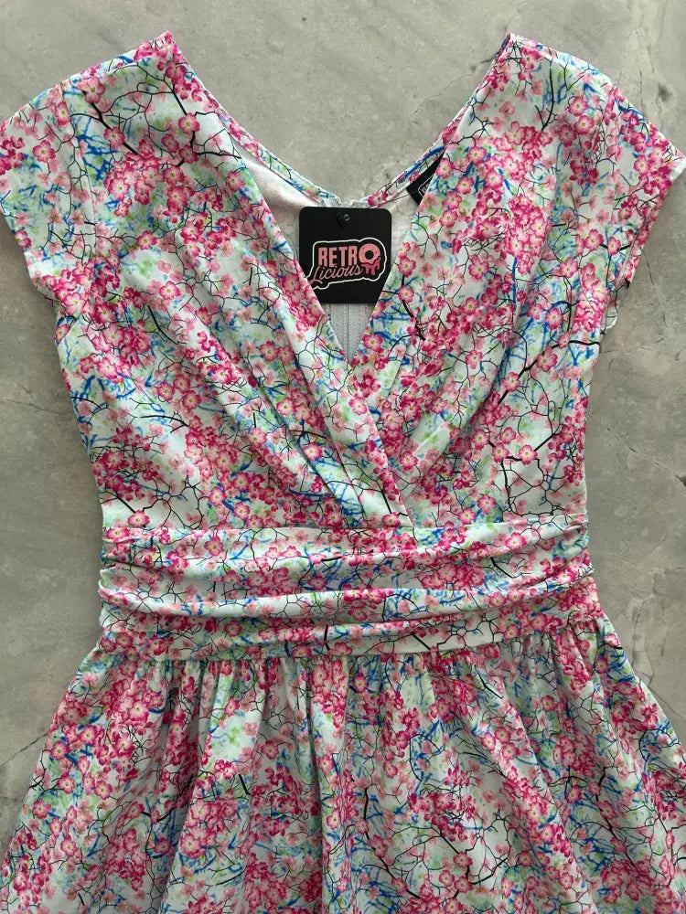 A pink and white floral print cotton dress with short flutter sleeves v-neckline and gathered waistband vintage style