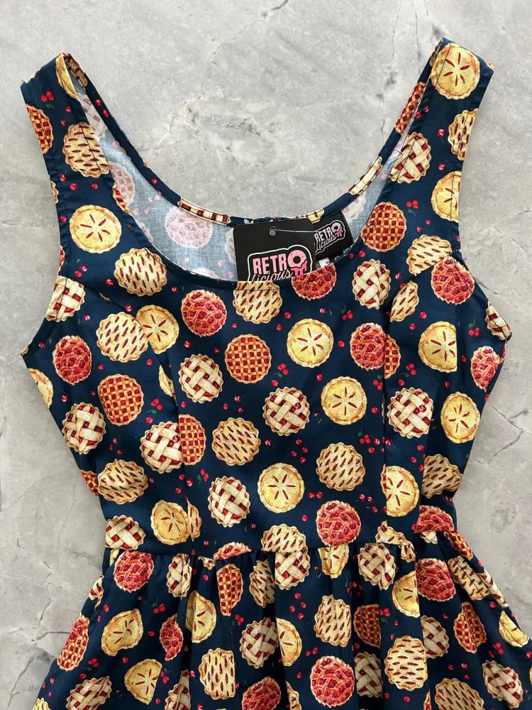 A navy blue sleeveless fit and flare mini dress with golden and red pie prints by retro vintage