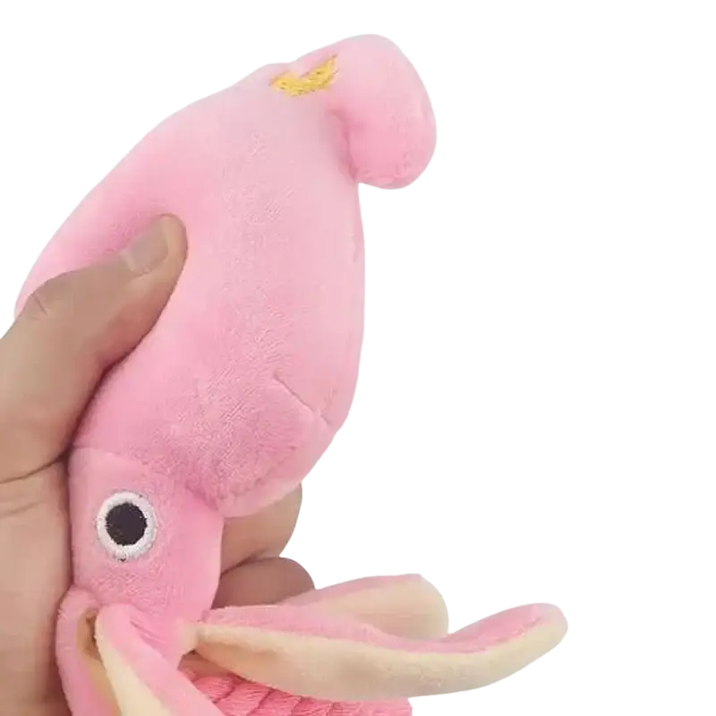 Pink plush squid chew toy with embroidered eyes and golden crown for dogs is a soft sound chew toy