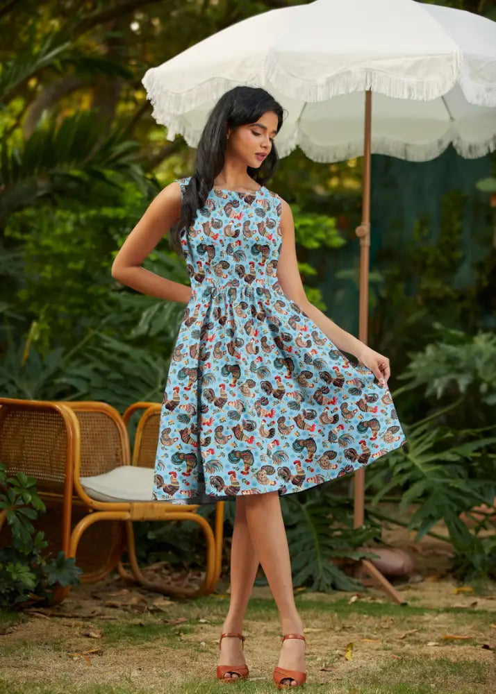 Light blue 1950s vintage sleeveless cotton a-line dress with brown and red rooster print and pockets on soft fabric