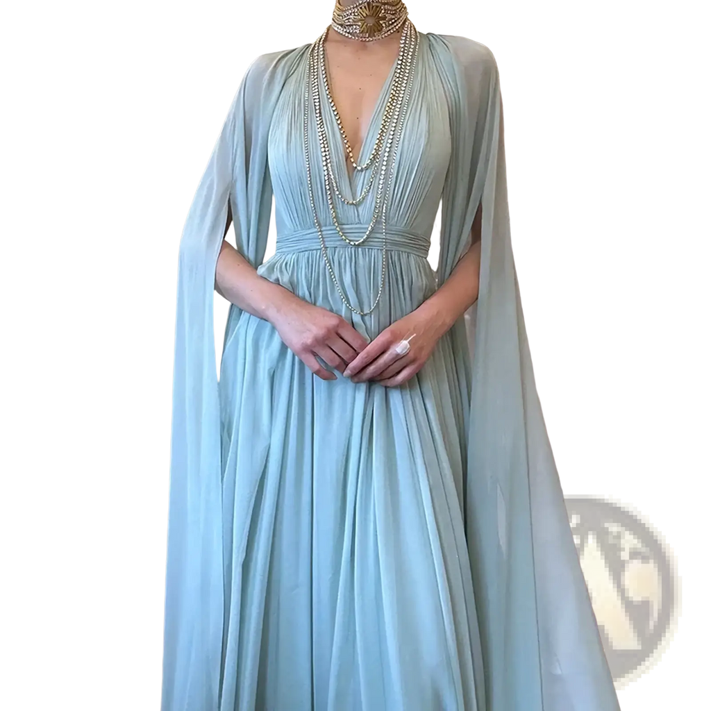A light blue chiffon cape evening dress with deep v-neckline and pleated long flowing maxi gown