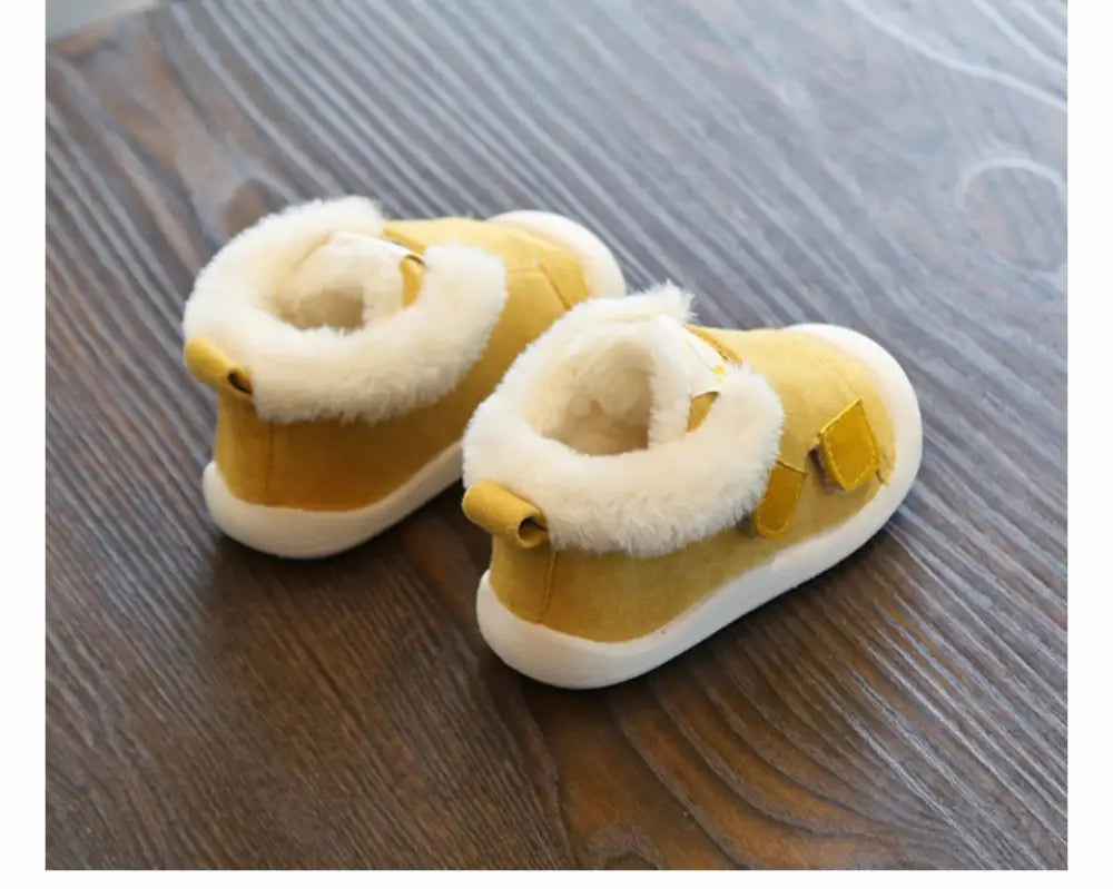 Yellow suede toddler snow boots with fluffy white faux fur lining and matching yellow buckle straps animal themed plush design