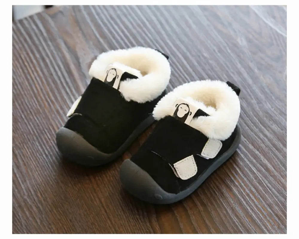 Black toddler snow boots with white faux fur lining and monkey face patch on the strap from animal themed plush collection