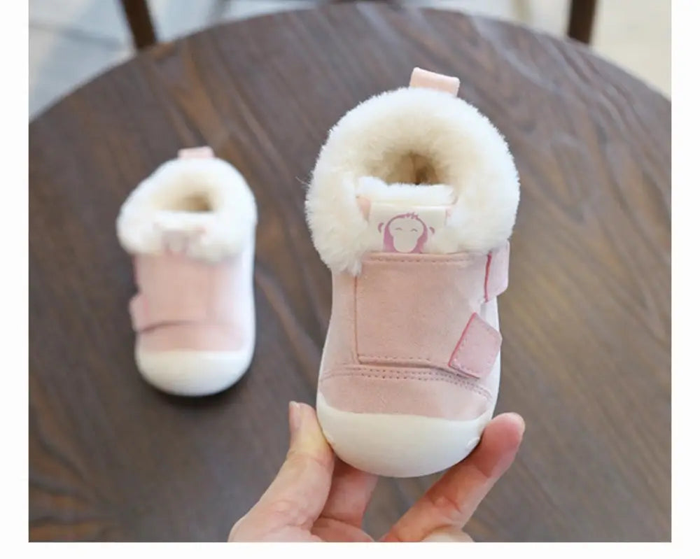 Pink animal themed plush faux fur toddler snow boot with fluffy white lining and a cute monkey face patch