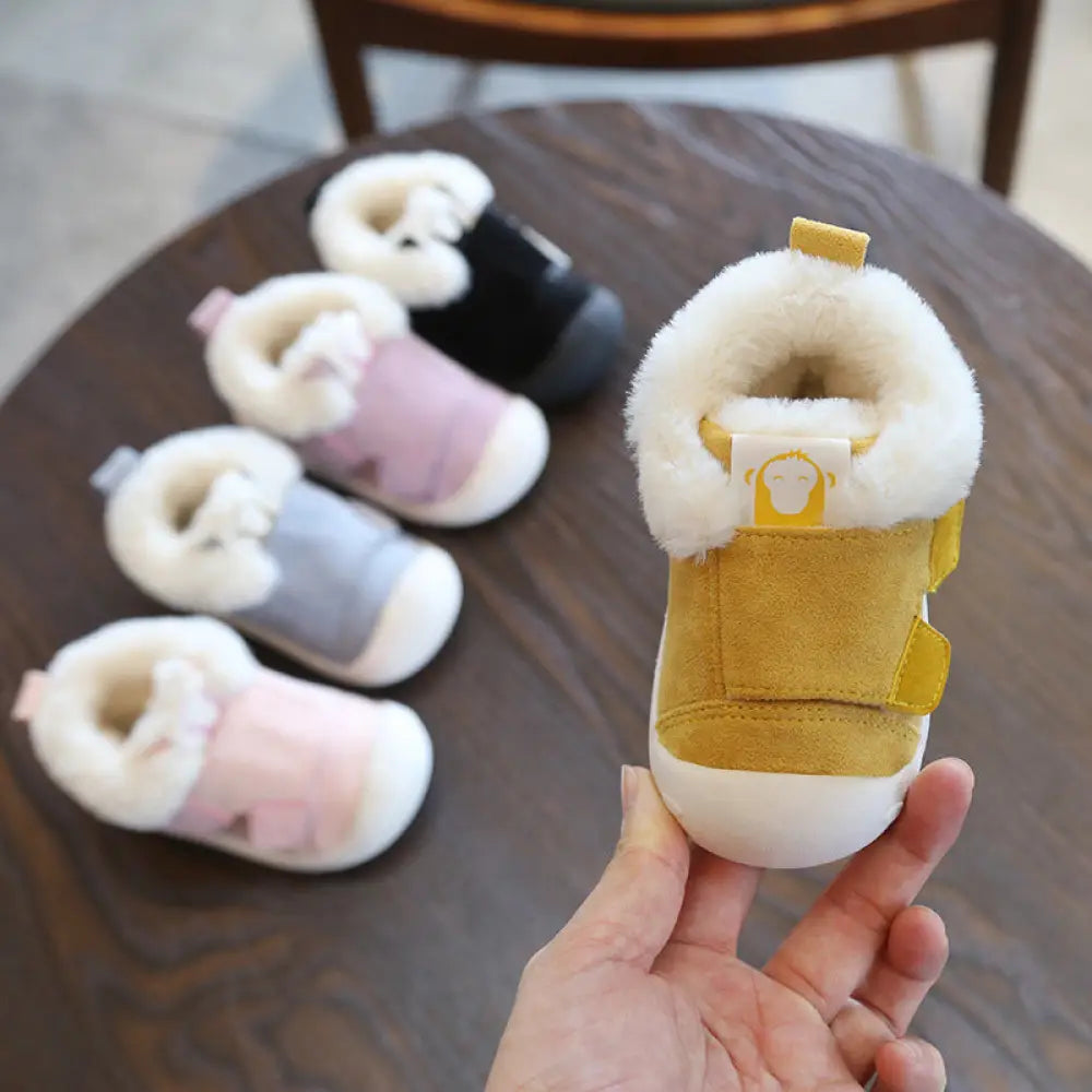 Yellow suede toddler snow boot with white plush faux fur lining and small monkey logo tag from animal themed collection