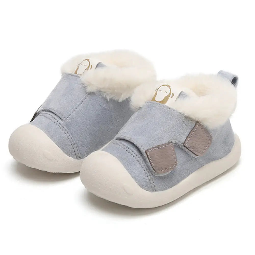 Light blue suede toddler snow boots with white faux fur lining and tan velcro straps featuring a monkey face design