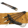 Set of six Chinese calligraphy brushes with dark brown wooden handles black ferrules and natural white-tipped bristles for writing practice