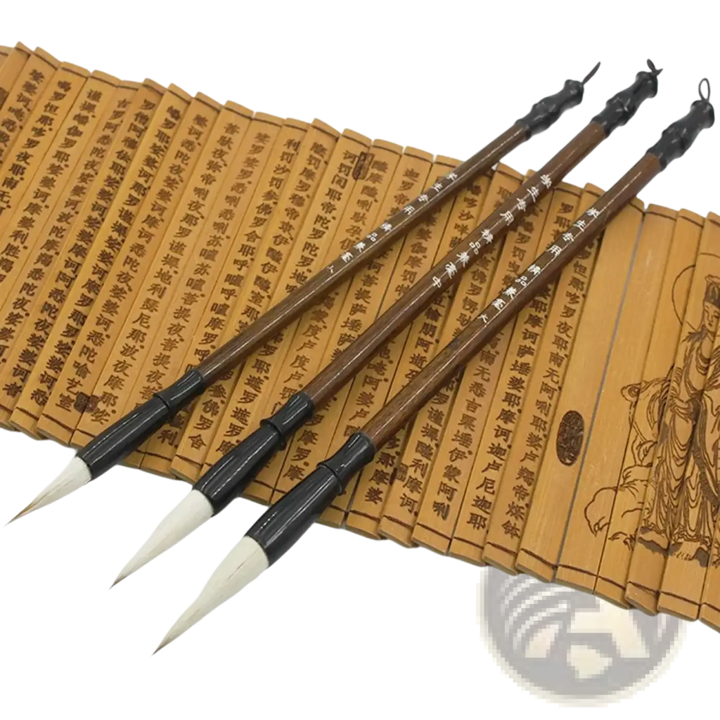 Three traditional chinese calligraphy brushes with dark brown wooden handles and white animal hair tips on bamboo scrolls