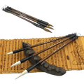 Set of six Chinese calligraphy brushes with dark brown wooden handles black ferrules and natural white-tipped bristles for writing practice