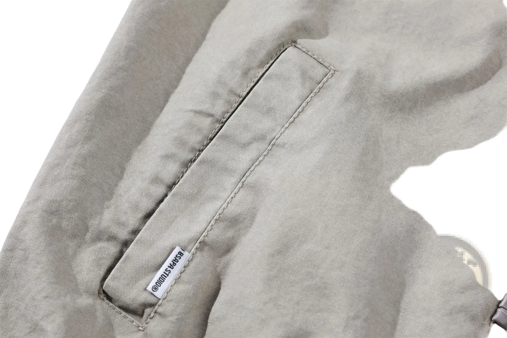 Beige canvas pocket with neat stitching and small white brand tag on a Chinese style men’s retro jacket