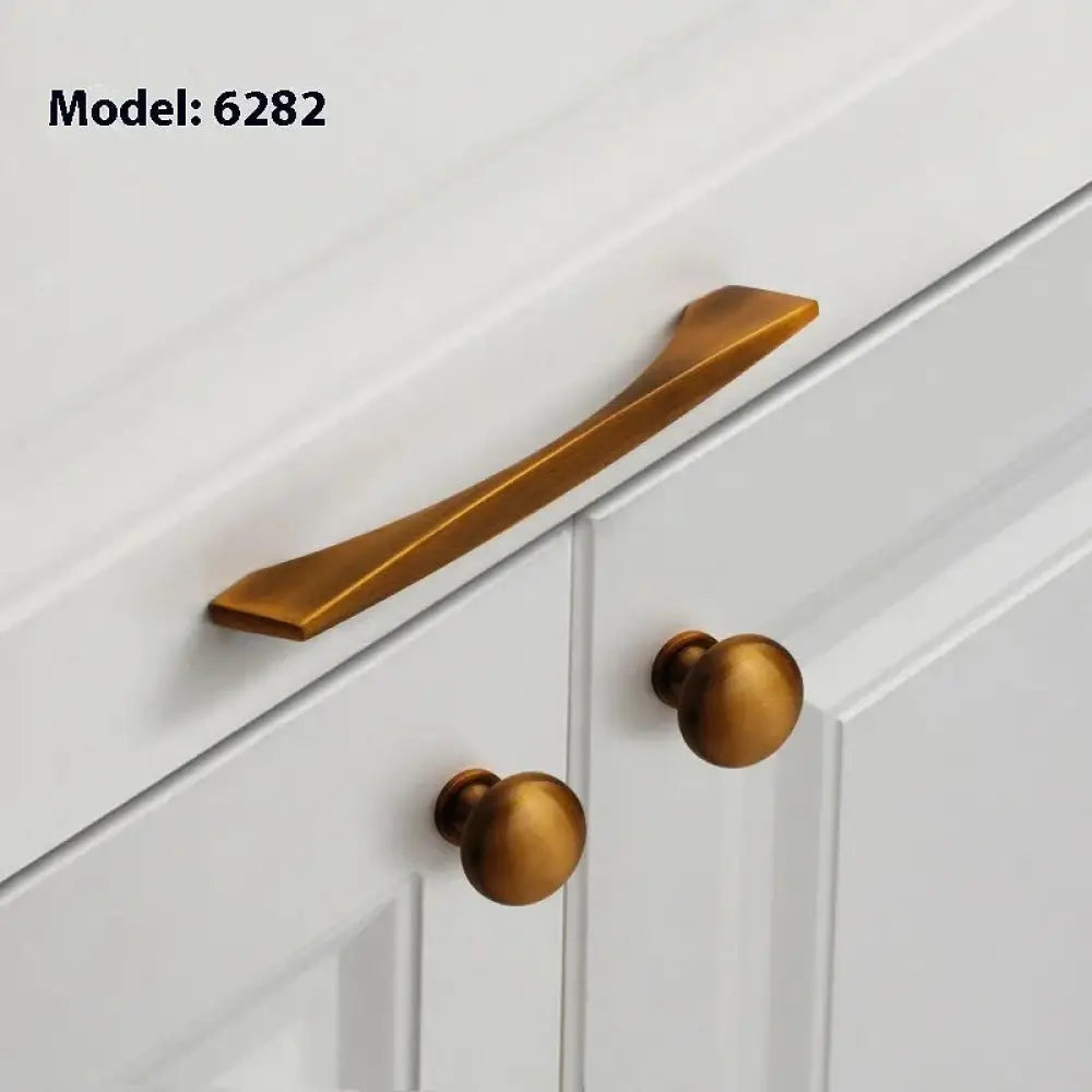 Minimalist brushed brass cabinet handle with bronze finish and sleek curved design for modern drawer pulls
