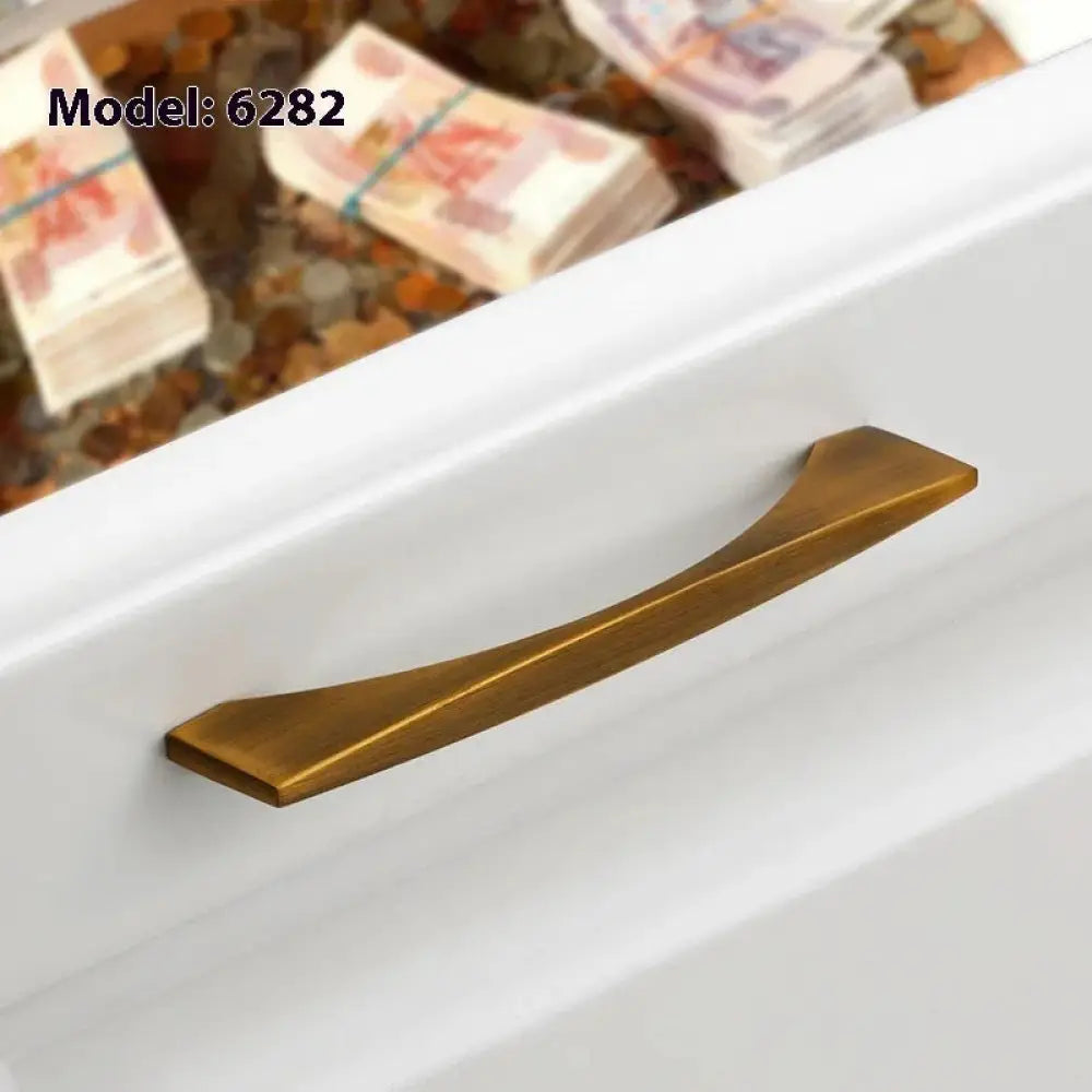 Minimalist brushed brass cabinet handle with a curved, brass-finished modern design for drawers and cabinets