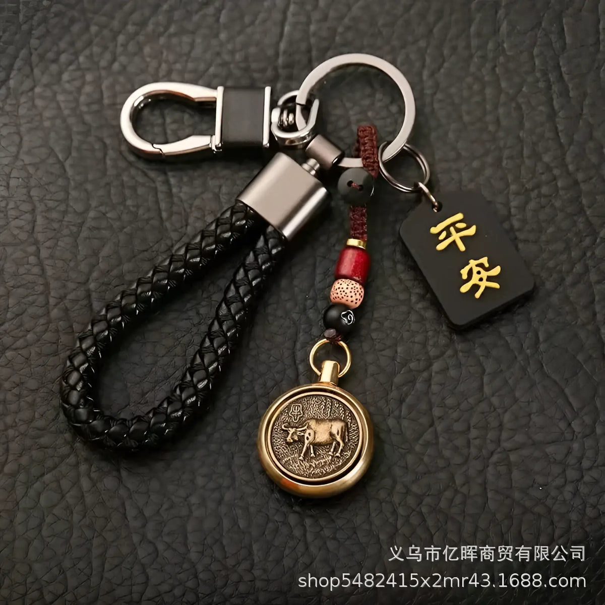 Black braided leather keychain with bronze cow medallion red and black beads and gold engraved Chinese tag