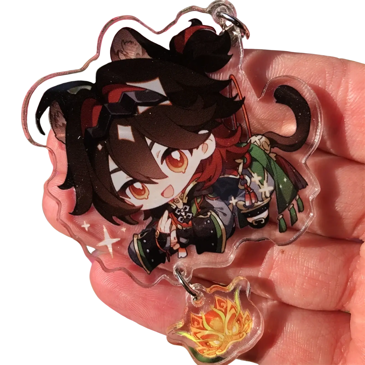 Clear acrylic chiori keychain featuring a chibi character with dark brown hair red eyes and green black star-patterned attire