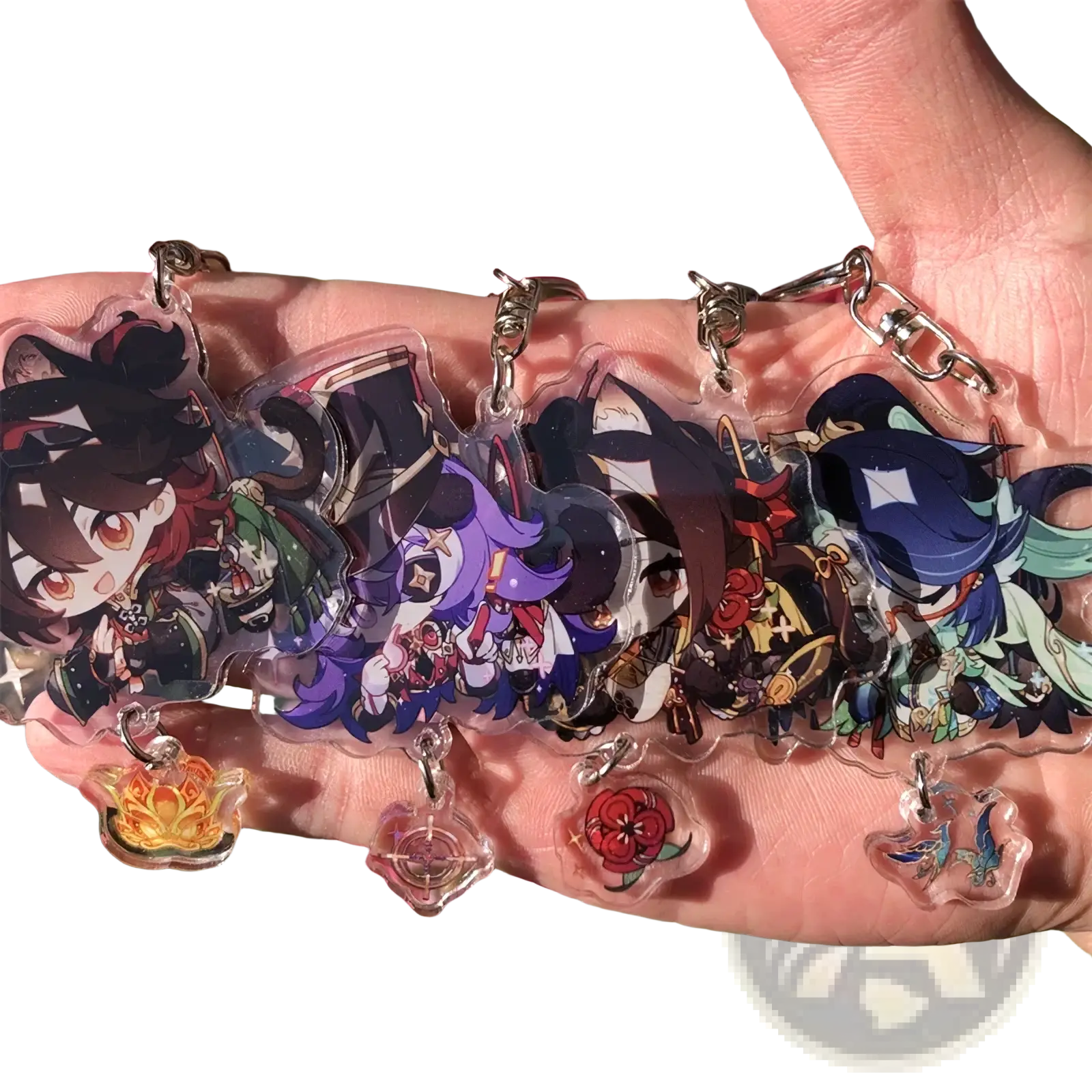 A hand holds clear acrylic chiori keychains with colorful anime designs silver clasps and matching charms