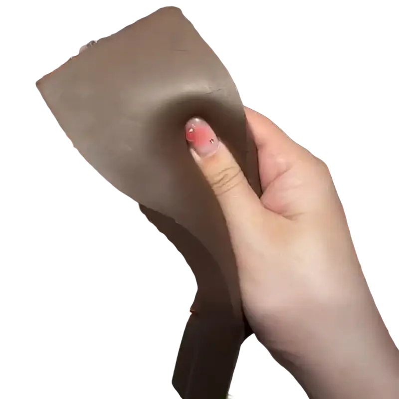 A soft matte brown chocolate bar squeeze toy held in hand for slow rising sensory fidget stress relief