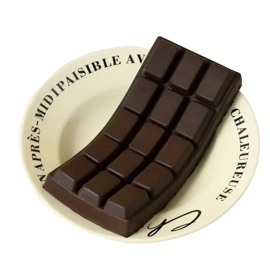 A dark chocolate squeeze toy with a glossy segmented design on a white plate for stress relief
