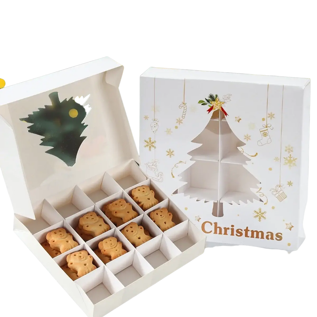 White christmas-themed gift box with gold foil paper-cut tree design containing golden-brown snowman cookies