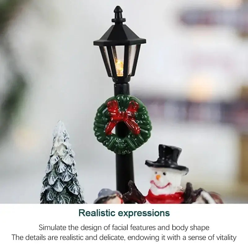 Black decorative lantern with glowing light and green wreath with red bow in a christmas house light display