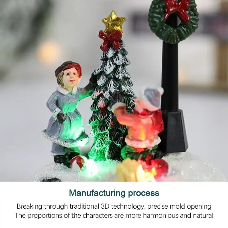 A christmas house light featuring a glowing green tree with red bow and gold star surrounded by festive figurines