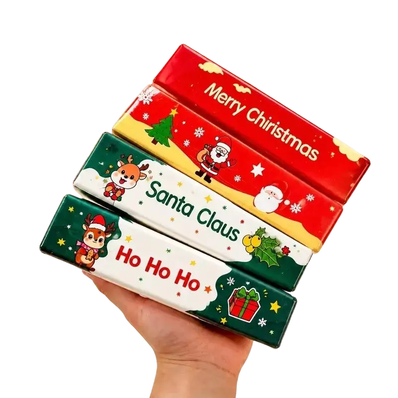 A hand holds a stack of colorful christmas santa squishy slow rising stress relief toy boxes with festive designs