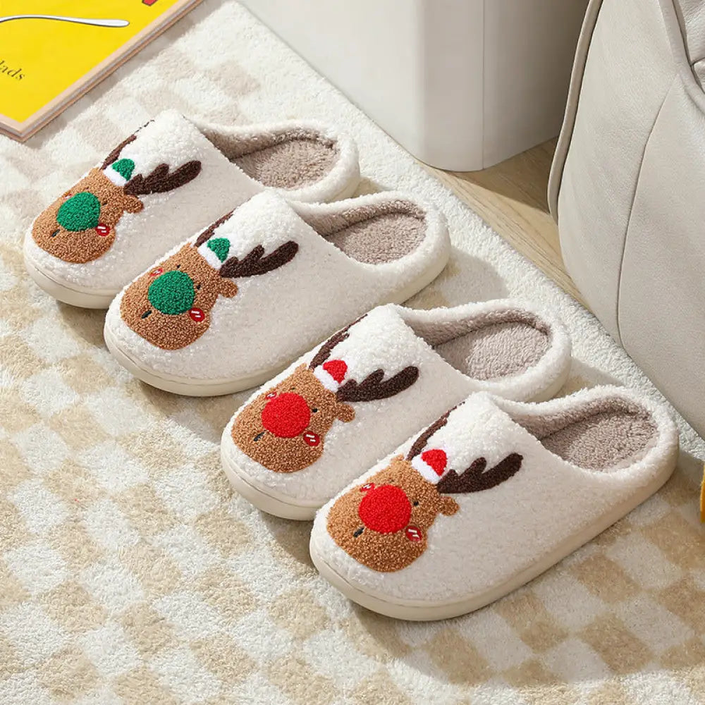 White plush reindeer Christmas slippers with embroidered faces brown antlers green and red noses and cozy faux fur