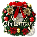 A festive green christmas wreath with a red velvet bow gold and red flowers and merry christmas wood lettering holiday decor