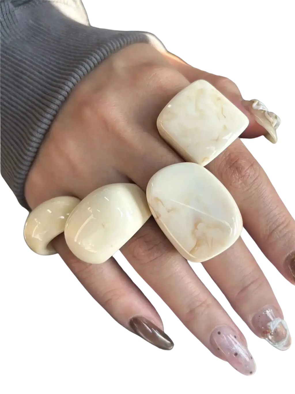 Cream-colored marbled chunky resin cocktail rings with smooth rounded edges worn on multiple fingers in 4-piece set