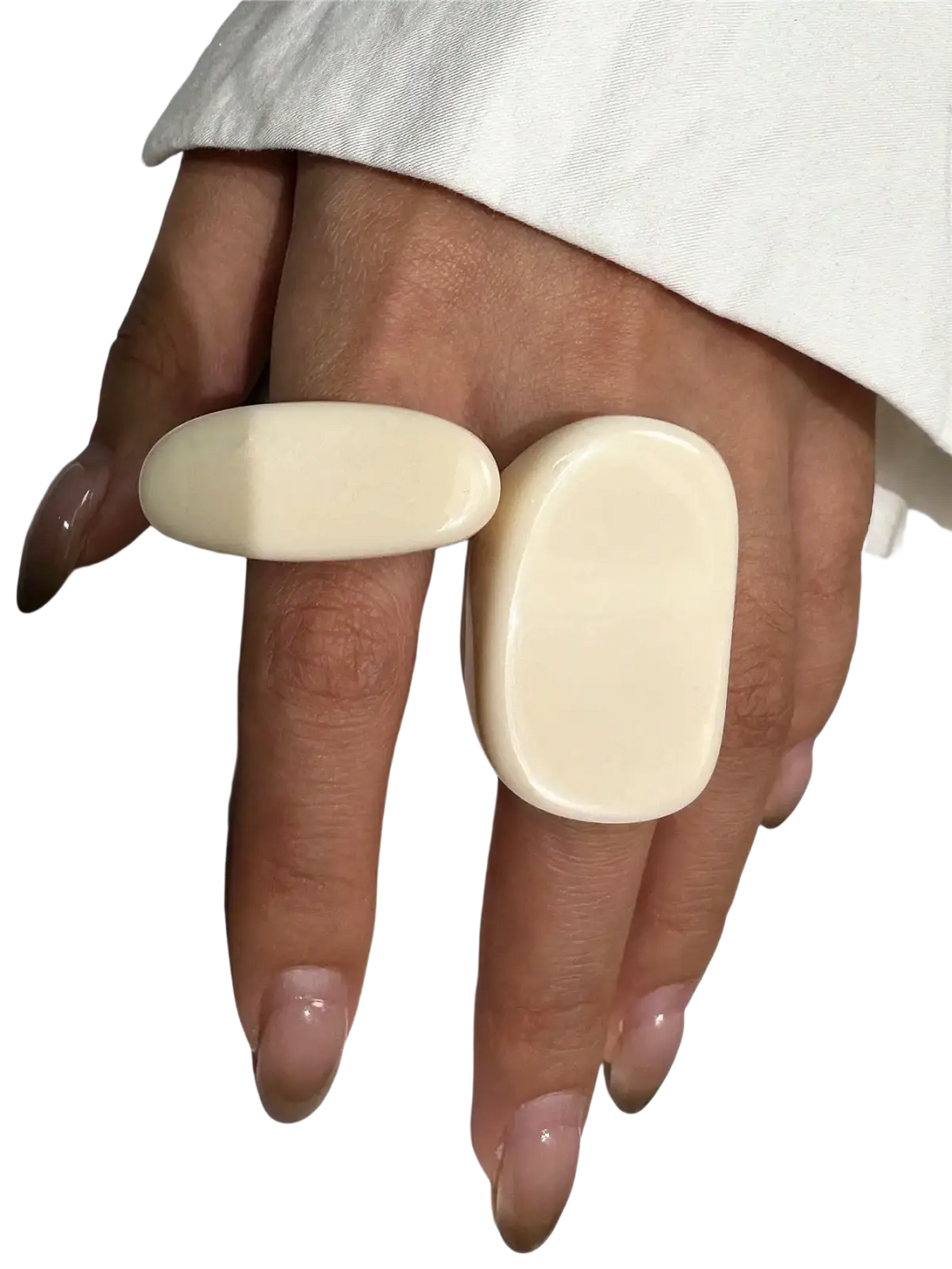 Cream-colored smooth resin chunky cocktail rings with rounded rectangular shapes worn on two fingers