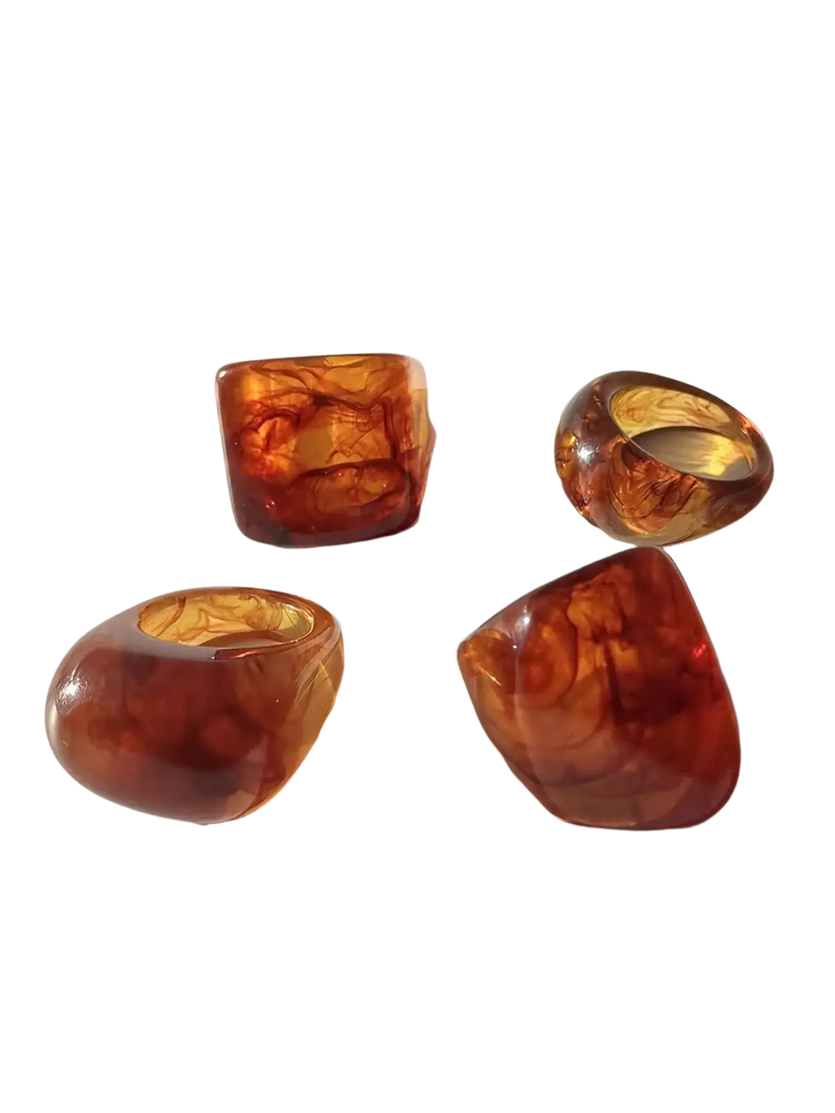 Set of four chunky resin cocktail rings in amber tones with translucent swirling marbled patterns