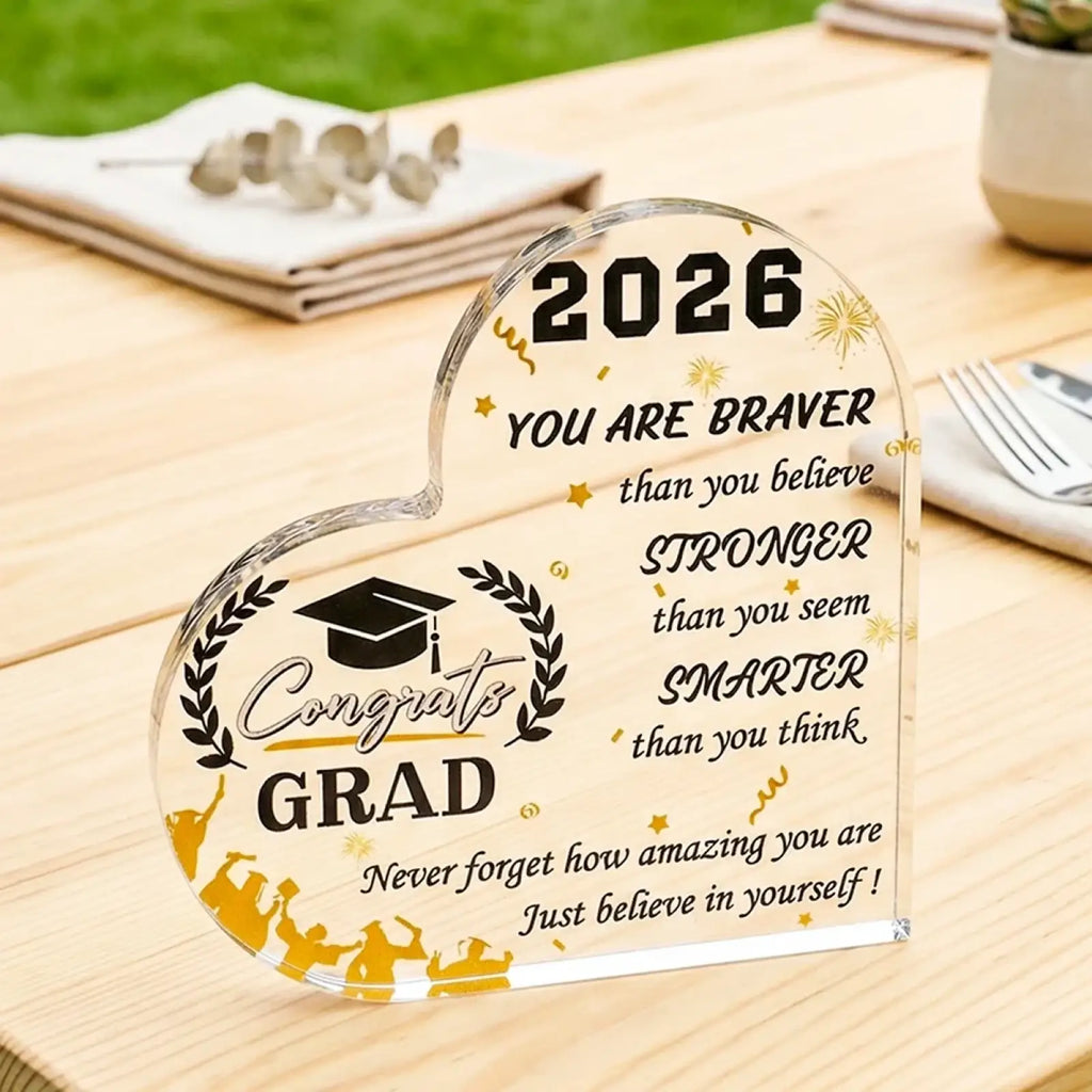 Clear acrylic heart-shaped class of 2026 graduation plaque with black and gold engraving and laurel wreath design