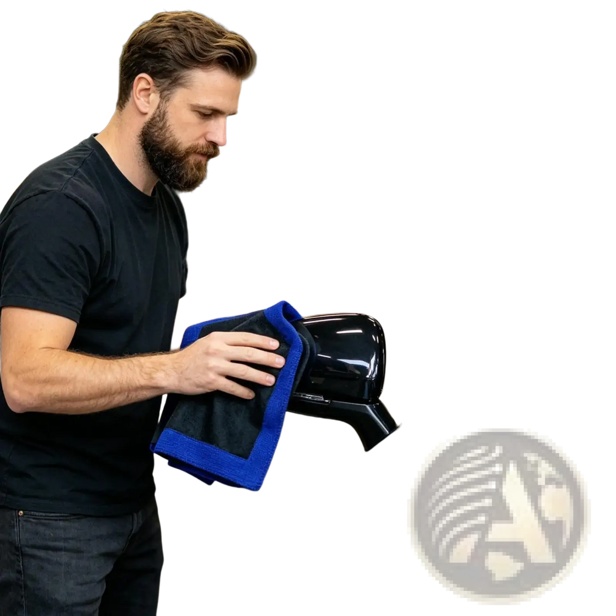 A man using a blue microfiber clay bar towel for car detailing and deep cleaning on a glossy black side mirror