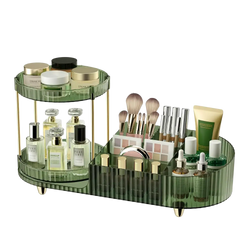 Green translucent two-tier clear acrylic rotating makeup organizer tray with gold-tone metal legs and dividers