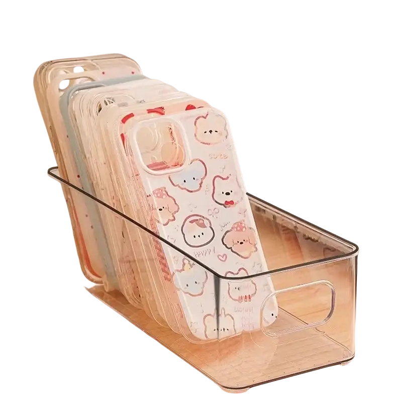 Clear plastic refrigerator organizer bin with handles holding multiple colorful cartoon-themed phone cases