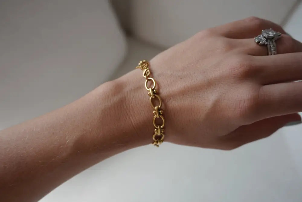 Cleo gold interlocking oval link chain bracelet featuring gold-toned metal worn on a wrist