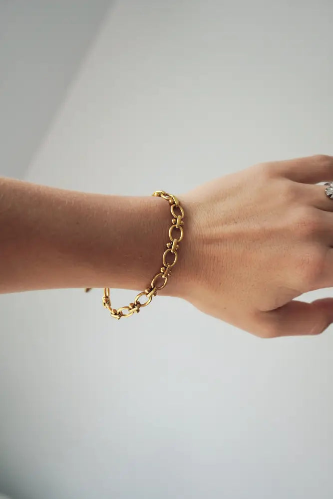 Cleo gold interlocking oval link chain bracelet featuring a bold gold-toned chain-link design worn on a wrist