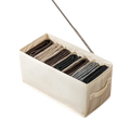 Beige fabric clothes storage box with seven compartments neatly organizing gray and black socks for wardrobe and jeans storage