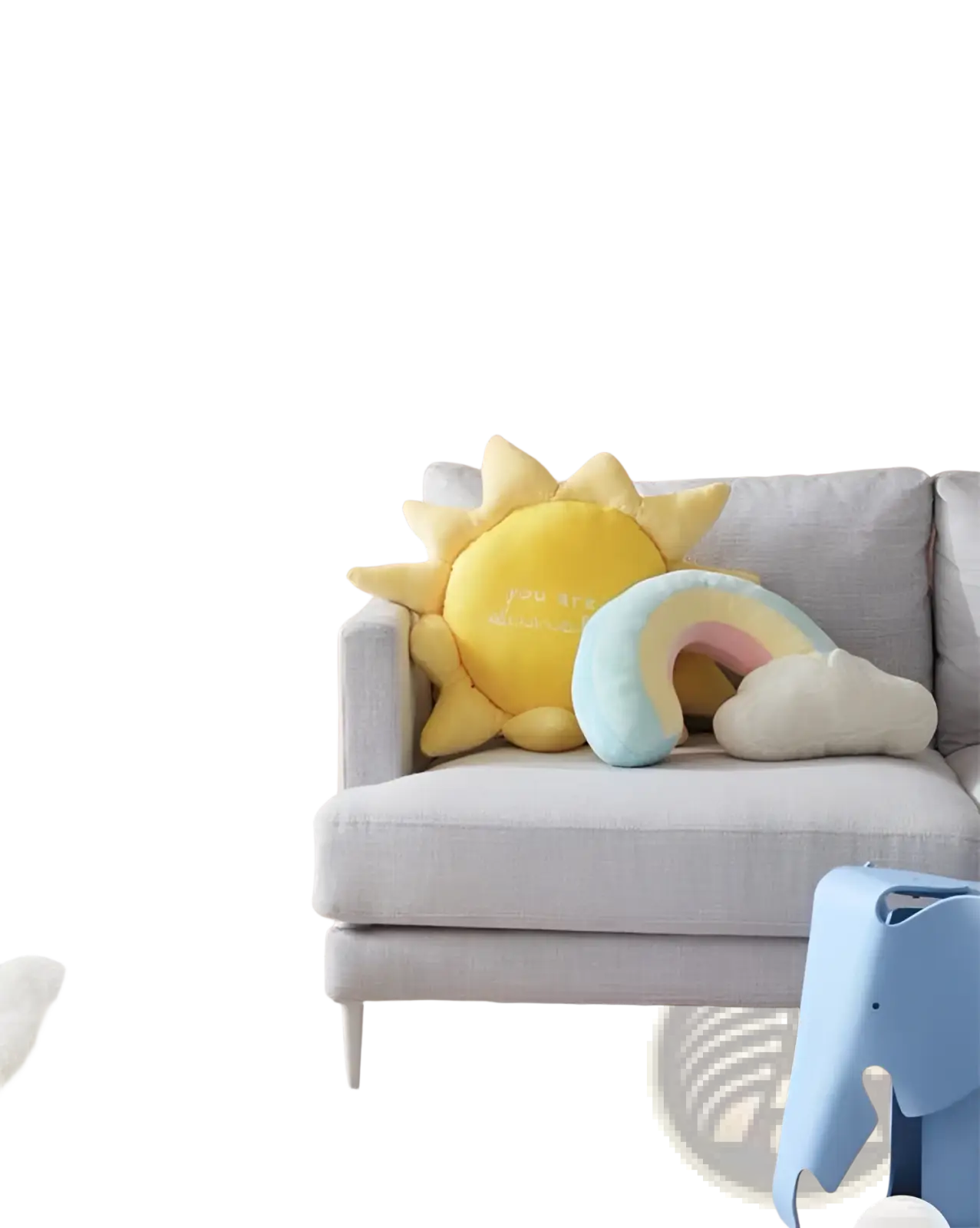 Soft yellow plush sun pillow with embroidered text and spiky rays resting on gray sofa for wall hanging decor