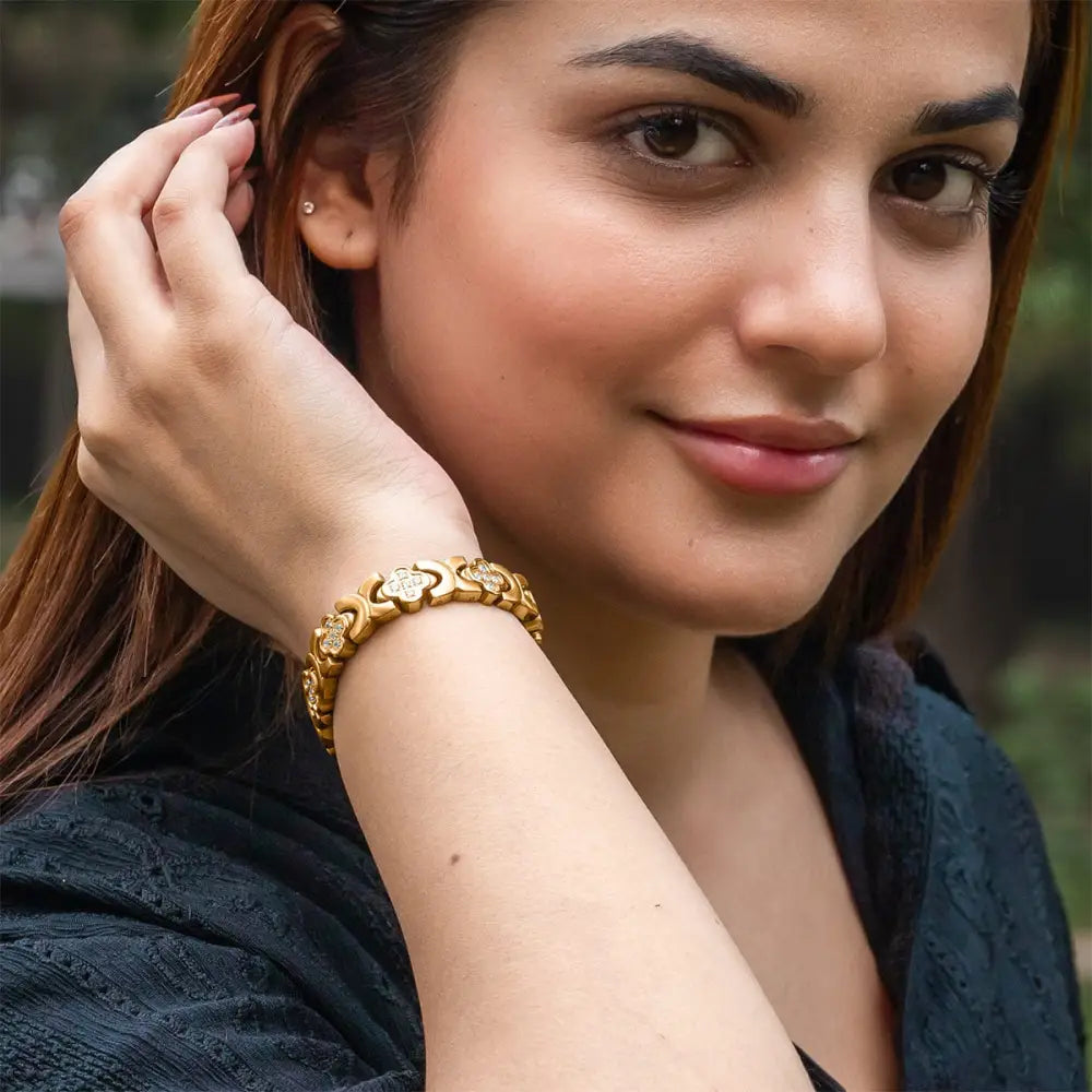 Gold crystal clover magnetic bracelet for women with gold-toned intricate floral links and embedded clear stones