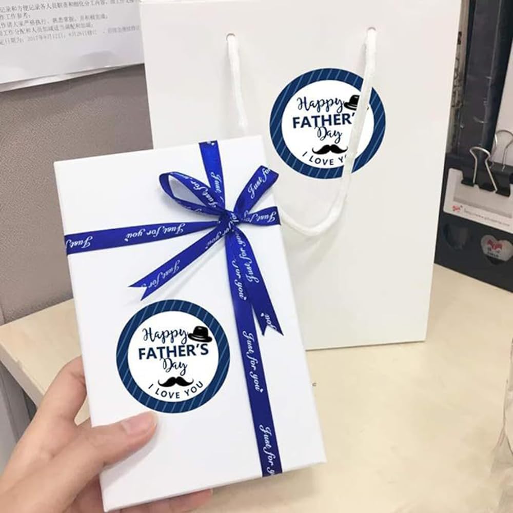 White rectangular gift box with a blue ribbon bow and a circular happy fathers day i love you sticker from a fathers day gift stickers roll.