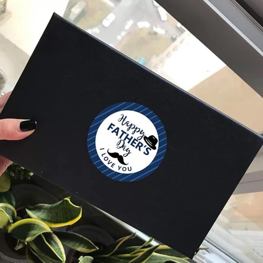 black rectangular gift box with a circular blue and white happy fathers day sticker featuring a top hat and mustache graphic from the fathers day gift stickers roll product.