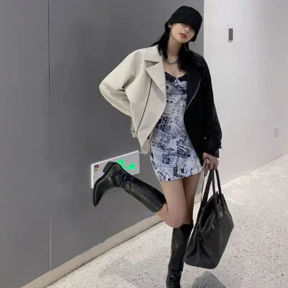 Black leather tote bag with structured shape and top handles paired with women’s colorblock loose fit pu leather biker jacket