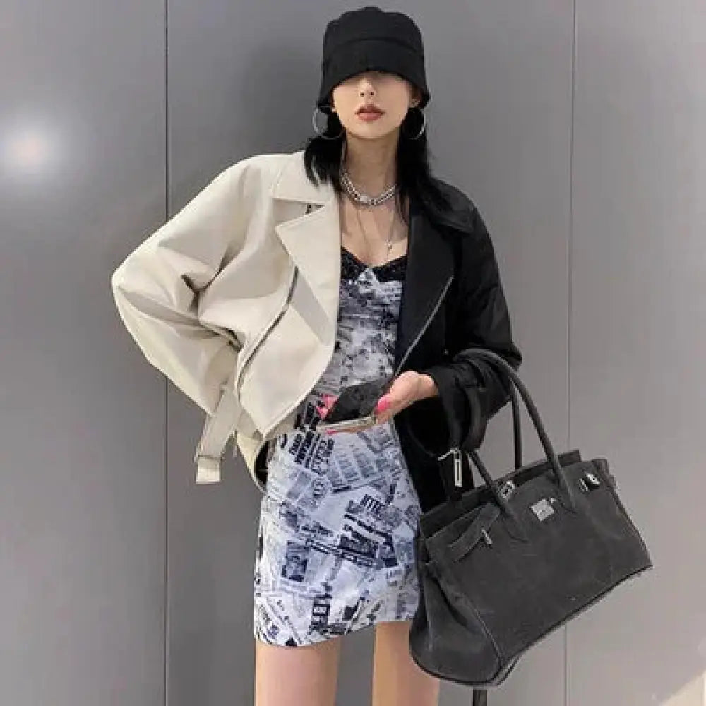 Black leather handbag with silver hardware and structured design complementing women’s pu leather biker jacket