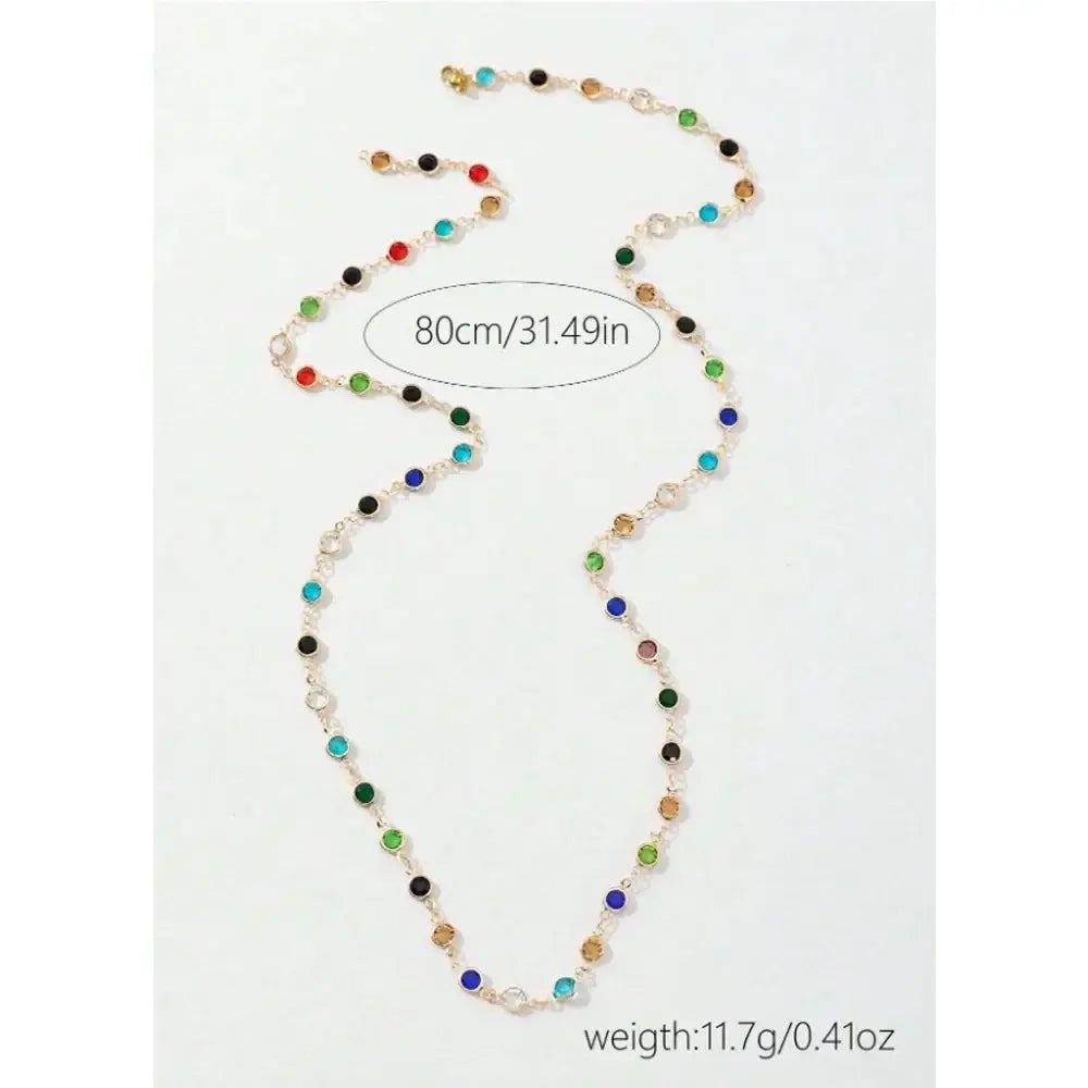 Colorful crystal tassel statement necklace featuring a gold-toned chain with red green blue black and clear stones