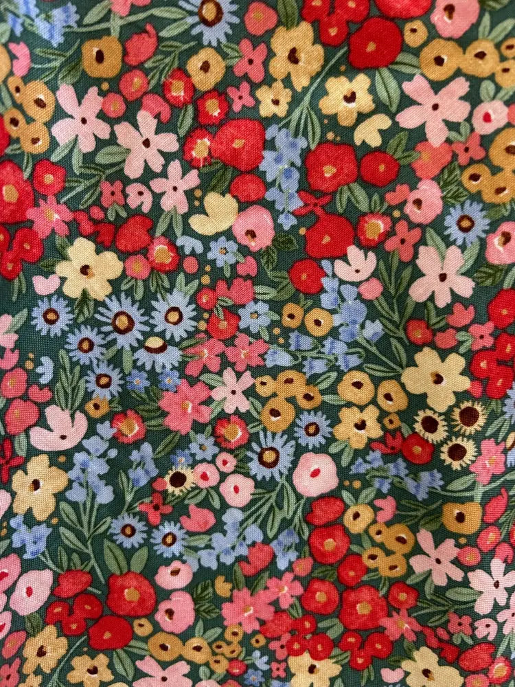 Vintage 1950s painted floral cotton A-line dress with pockets featuring vibrant red pink yellow and blue flowers on dark green