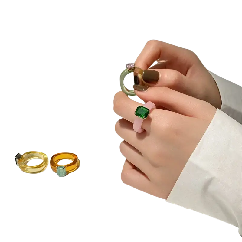 A hand holds a mint green colorful resin crystal geometric ring with a clear faceted gemstone for women
