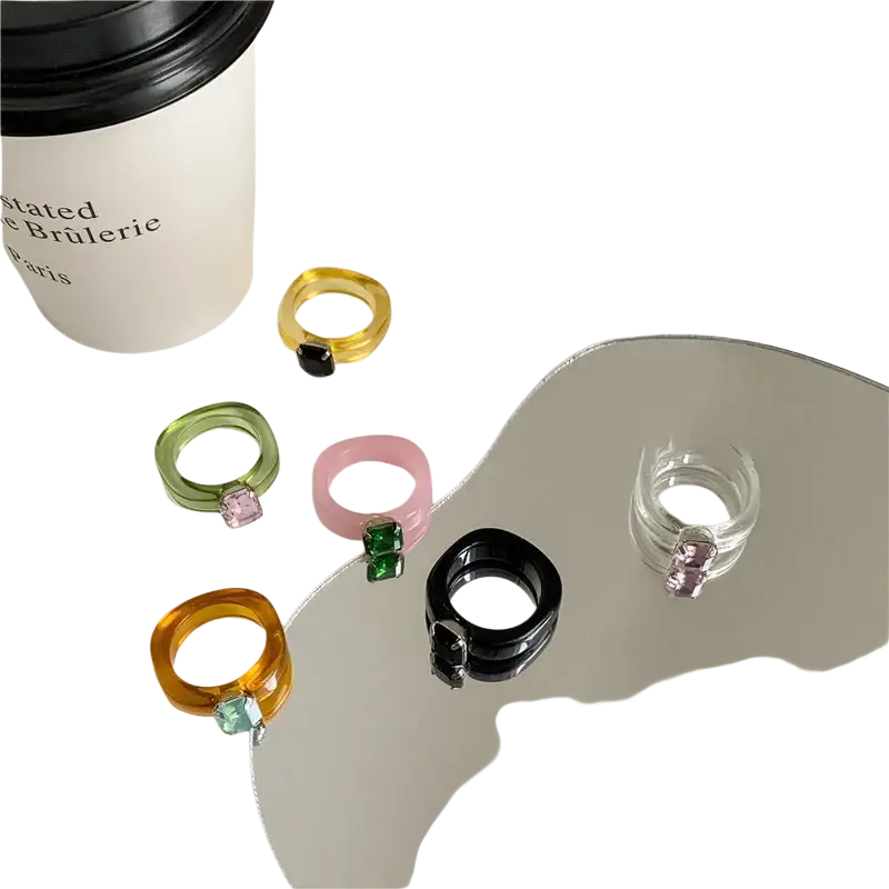 A set of colorful resin crystal geometric rings with square-cut gemstones in yellow green pink orange black and clear
